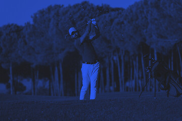 Image showing golfer hitting a sand bunker shot on sunset