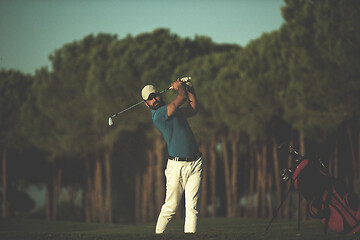 Image showing golfer hitting a sand bunker shot on sunset