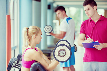 Image showing young sporty woman with trainer exercise weights lifting