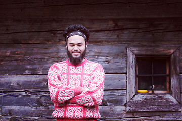 Image showing portrait of young hipster in front of wooden house