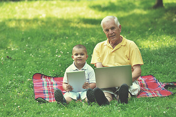 Image showing grandfather and child using laptop