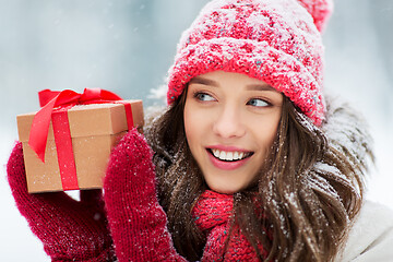 Image showing happy young woman with christmas gift in winter