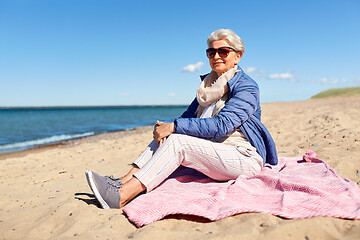 Image showing happy senior woman in jacket on beach