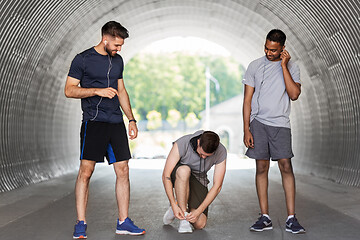 Image showing male friends with earphones training outdoors