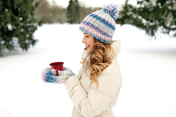 Image showing happy young woman with tea cup outdoors in winter