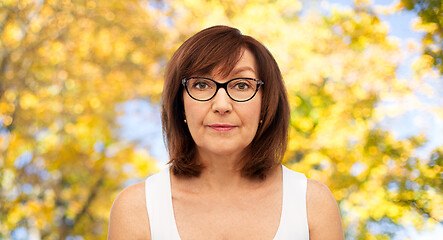 Image showing portrait of senior woman in glasses over autumn