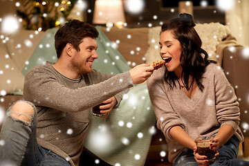 Image showing happy couple eating waffles with cacao at home