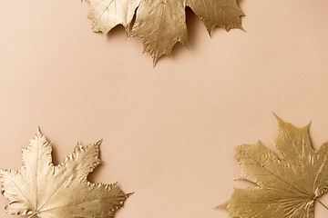 Image showing golden maple leaves on beige background