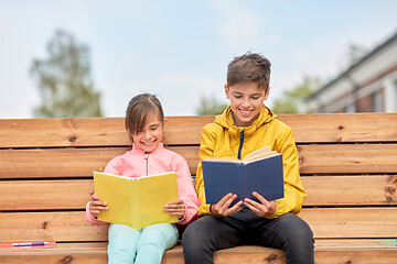 Image showing school children reading books sitting on bench