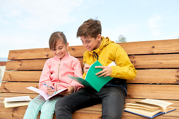 Image showing school children with notebooks sitting on bench