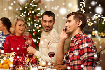 Image showing man calling on smartphone at christmas dinner