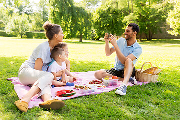 Image showing father taking picture of family on picnic at park