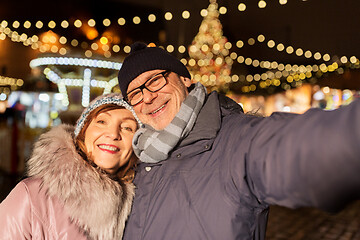 Image showing senior couple taking selfie at christmas market