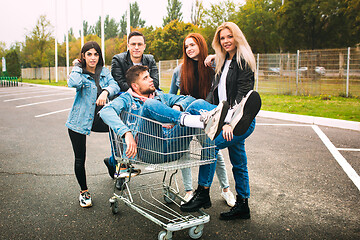 Image showing Group of four young diverse friends in jeanse outfit look carefree, young and happy on city\'s streets