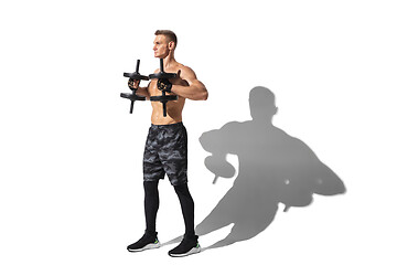 Image showing Beautiful young male athlete practicing on white studio background with shadows