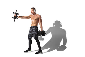 Image showing Beautiful young male athlete practicing on white studio background with shadows