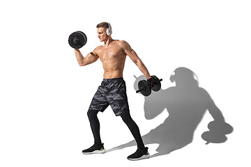 Image showing Beautiful young male athlete practicing on white studio background with shadows