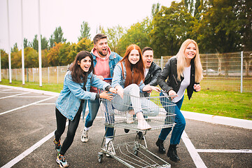 Image showing Group of four young diverse friends in jeanse outfit look carefree, young and happy on city\'s streets