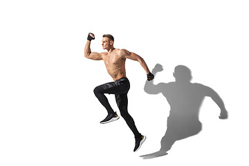 Image showing Beautiful young male athlete practicing on white studio background with shadows