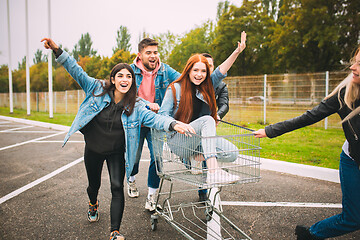 Image showing Group of four young diverse friends in jeanse outfit look carefree, young and happy on city\'s streets