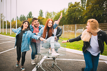 Image showing Group of four young diverse friends in jeanse outfit look carefree, young and happy on city\'s streets