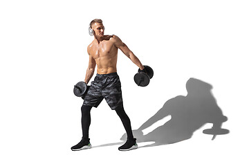 Image showing Beautiful young male athlete practicing on white studio background with shadows