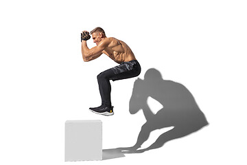 Image showing Beautiful young male athlete practicing on white studio background with shadows