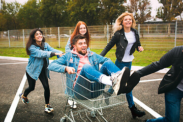 Image showing Group of four young diverse friends in jeanse outfit look carefree, young and happy on city\'s streets