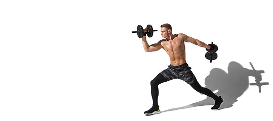 Image showing Beautiful young male athlete practicing on white studio background with shadows