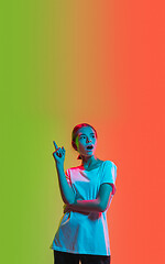 Image showing Young caucasian girl\'s portrait on gradient green-orange studio background in neon light