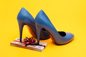 Image showing On a gift pack of five thousandth notes are women\'s blue high-heeled shoes