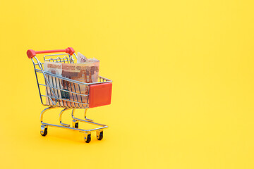 Image showing In the grocery cart lies a pack of five thousandth Russian bills, yellow background