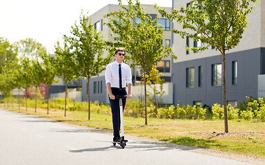 Image showing young businessman riding electric scooter outdoors