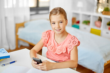 Image showing happy student girl using smartphone at home