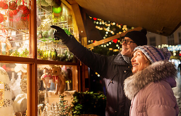 Image showing happy senior couple hugging at christmas market