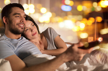 Image showing happy couple watching tv in bed at night at home