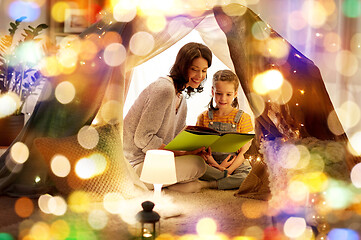 Image showing happy family reading book in kids tent at home