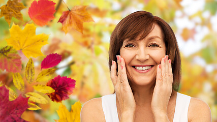 Image showing portrait of smiling senior woman touching her face