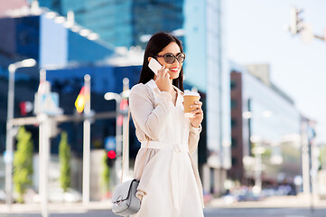 Image showing smiling asian woman calling on smartphone in city