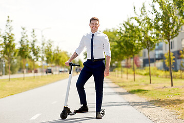 Image showing young businessman with electric scooter outdoors