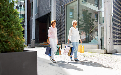 Image showing senior women with shopping bags walking in city