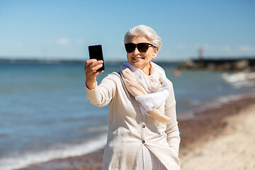 Image showing senior woman taking selfie by smartphone on beach