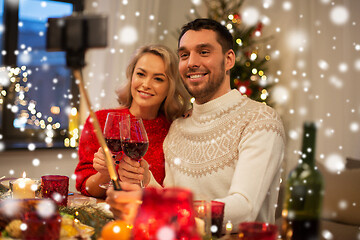 Image showing couple taking picture by selfie stick at christmas