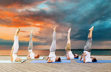 Image showing people making yoga in shoulderstand pose on mat