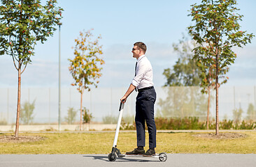 Image showing young businessman riding electric scooter outdoors