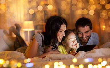 Image showing family with tablet pc in bed at night at home