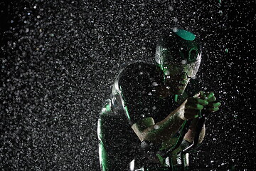 Image showing triathlon athlete riding bike fast on rainy night