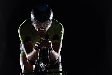 Image showing triathlon athlete riding bike fast at night