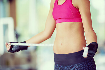 Image showing young fit woman measuring belly