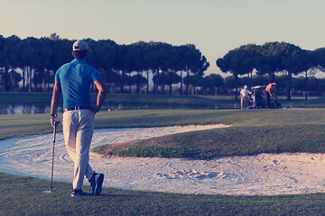 Image showing golfer from back at course looking to hole in distance